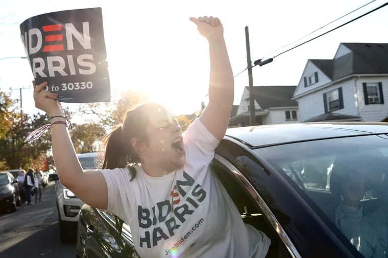Joe Biden supporter Ceyonna Rybitski celebrates from a car as she passes by fellow supporters gathered in front of Biden’s childhood home in Scranton, Pa., on Saturday, Nov. 7, 2020, after news outlets named Biden as the president-elect.
