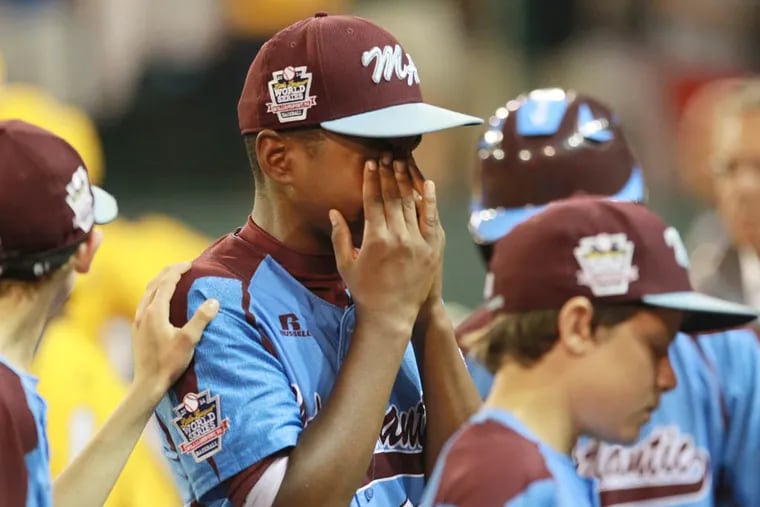 Taney's Joe Richardson, center, has to cover his tears as he walks to the dugout after the lost to Jackie Robinson West, 6-5.  ( MICHAEL BRYANT  / Staff Photographer )