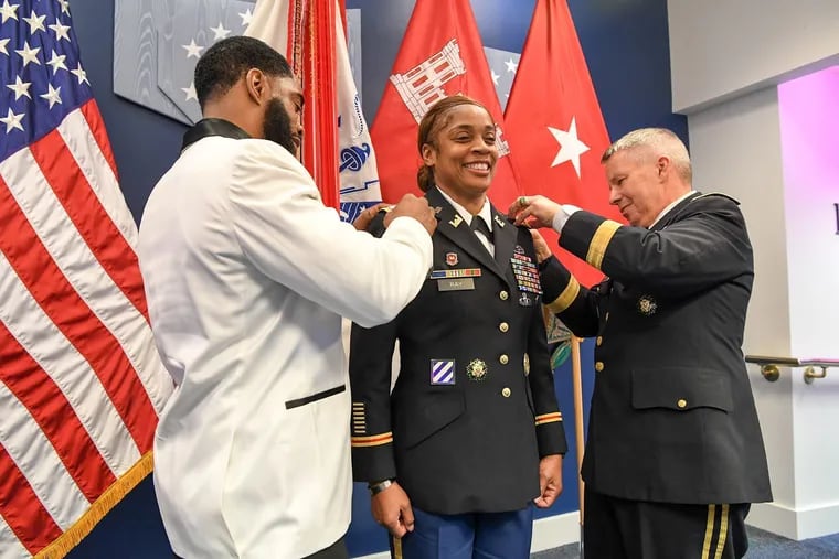 U.S. Army Colonel Lynn Ray, center, receives the Eagle Rank pins during her promotion ceremony to Colonel from her brother Yvon Dessus, left, and Lieutenant General Todd T. Semonite, right, the Commanding General of the U.S. Army Corps of Engineers.