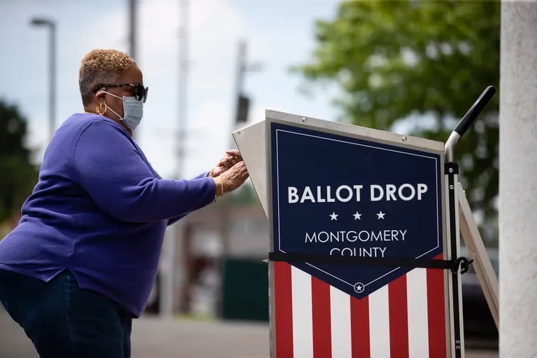 A voter puts a primary election mail ballot in a drop box in Willow Grove, Pa., on May 27, 2020.