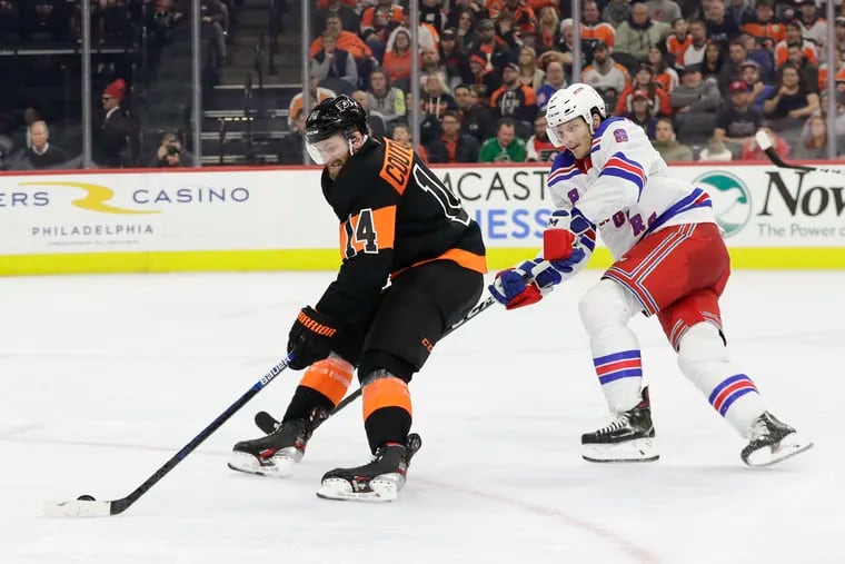 Flyers center Sean Couturier skates with the puck against New York Rangers defenseman Jacob Trouba in  game last month.