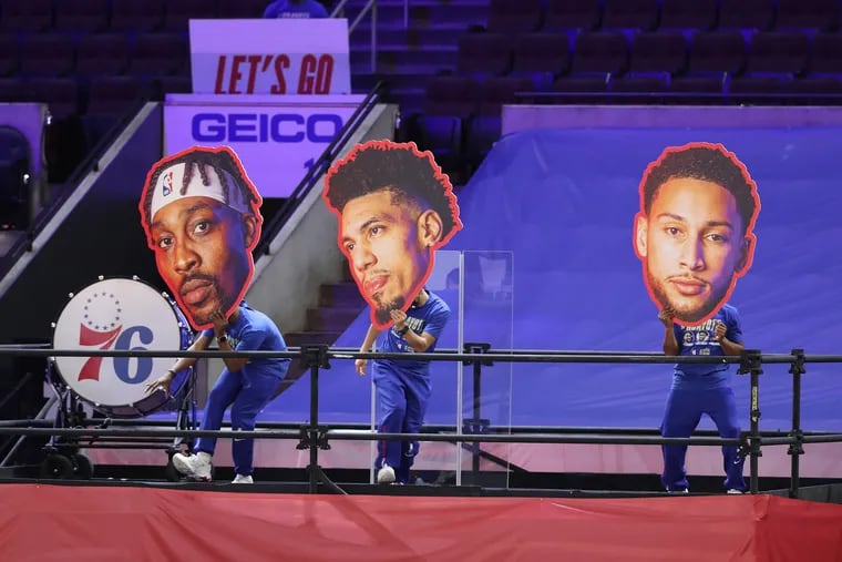 Dancers hold up large cutouts of the heads of (from left to right) the Sixers' Dwight Howard, Danny Green, and Ben Simmons before the game.