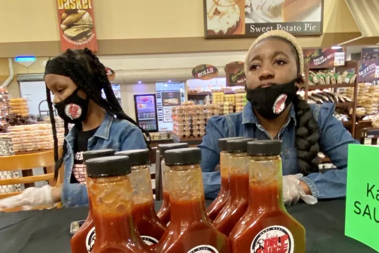 Akai Clarke-Perry (right) with her friend Ava Storm as she sells Kai's Drip Sauce at the ShopRite store in Nicetown on May 6, 2021.
