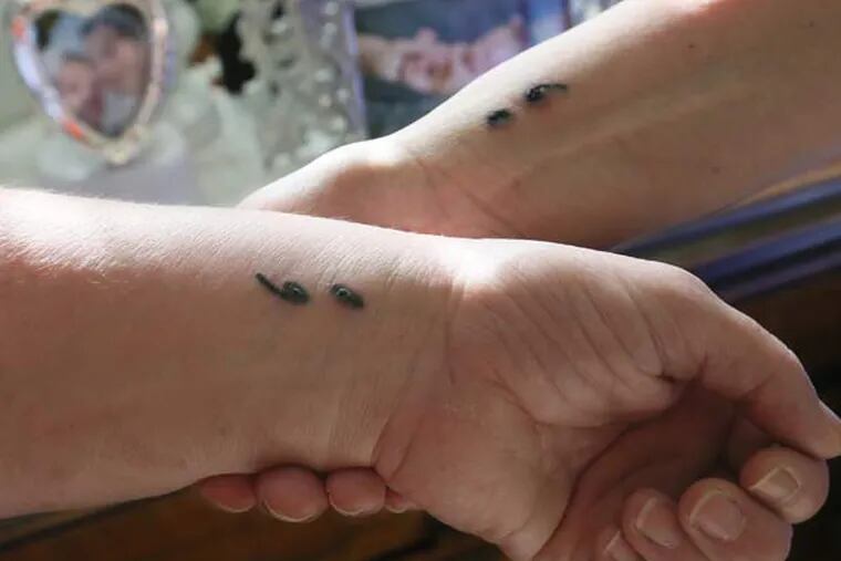 Sisters Robin Francini, left, and Justine Yoho were recently inked with a semi-colon. (Phil Masturzo/Akron Beacon Journal/TNS)