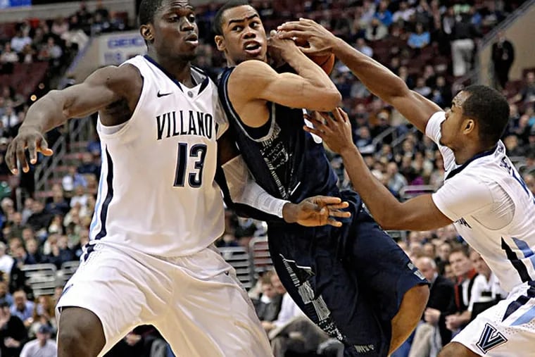 Georgetown's Markel Starks (middle) drives between Villanova's Tony Chennault (right) and Mouphtaou Yarou (left) during the first half of an NCAA college basketball game, Wednesday, March 6, 2013, in Philadelphia. (Michael Perez/AP)