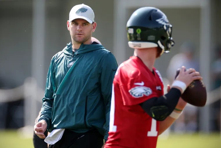 Press Taylor (left) was the quarterbacks coach for the Eagles before his promotion. Here he watches quarterback Carson Wentz throw during training camp in July 2019.