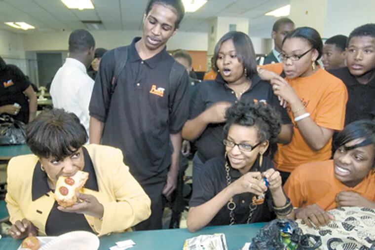 Awaiting the verdict, Overbrook High students watch as new schools chief Arlene Ackerman takes a bite of cafeteria pizza on her visit to the school. She said her lunch was &quot;just great.&quot; (Clem Murray/Inquirer)
