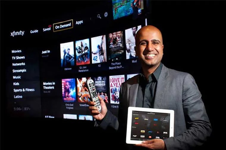 Sree Kotay, chief software architect, stands in Comcast's demonstration room in front of a giant screen displaying X1, the company's five-tuner digital-video recorder. (Ed Hiller / Staff Photographer)
