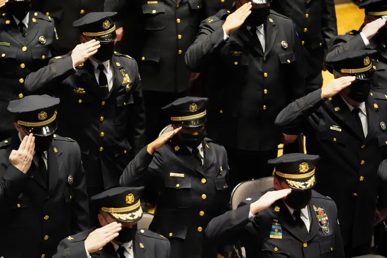 Recently promoted officers salute at a Philadelphia Police Promotion Ceremony held at the Temple Preforming Arts Center in Philadelphia, Pa., on December 15, 2021.