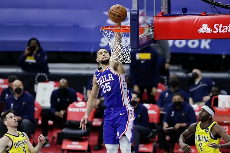 Sixers guard Ben Simmons dunks the ball as Indiana Pacers guards T.J. McConnell and Justin Holiday look on during the third quarter on Monday.