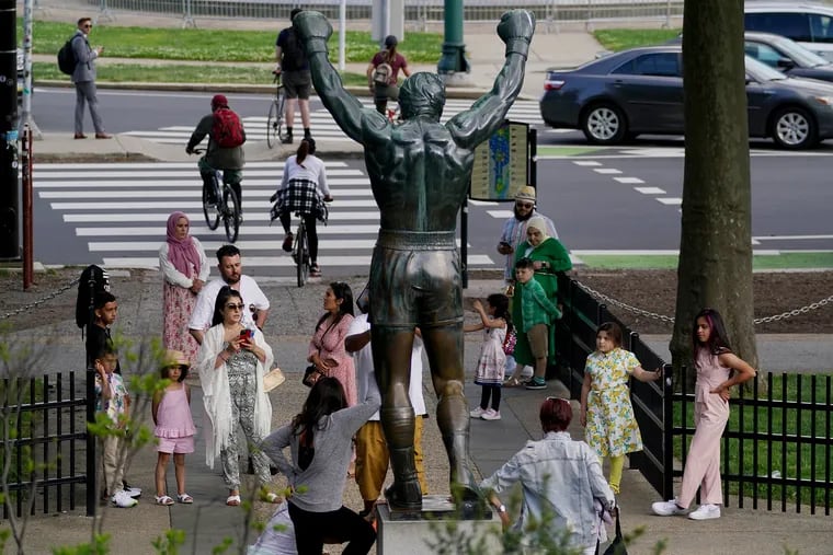 People pose for pictures in front of the Rocky statue outside the Philadelphia Museum of Art in Philadelphia on May 13, 2021. The CDC said Thursday that people who are fully vaccinated against COVID-19 do not need to wear masks during most indoor and outdoor activities.