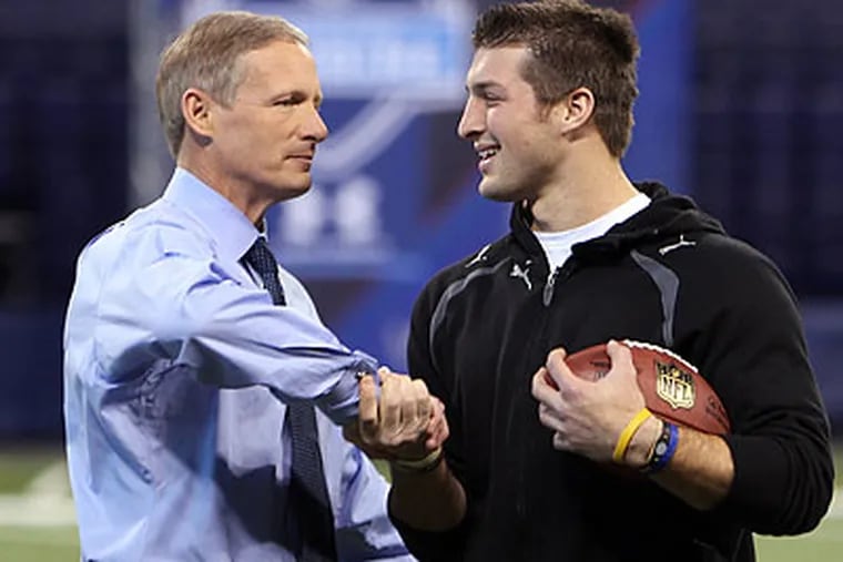 NFL Network's Mike Mayock poses with Broncos quarterback Tim Tebow at the 2010 NFL Combine. (Ben Liebenberg/AP file photo)