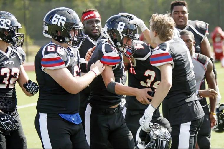 Germantown Academy’s Michael Capone (9) is congratulated after overtime PAT that beat Father Judge on Saturday.