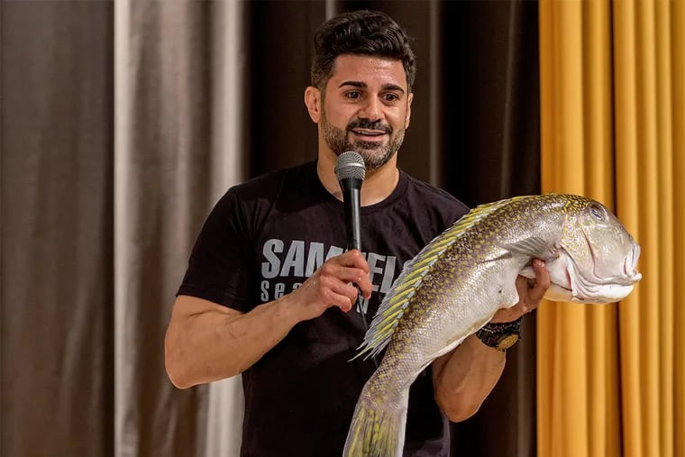 Joe Buonadonna, of Samuel's & Son Seafood, shows students a Tile fish caught off the New Jersey coast at a cooking demonstration with Blair House Executive Chef Ian Knox at the Springville School in Mount Laurel, New Jersey.