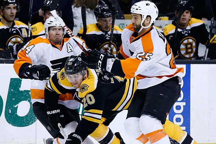 Boston Bruins' Daniel Paille (20) skates between Philadelphia Flyers'
Kimmo Timonen, left, of Finland, and Maxime Talbot (25) in the second
period of an NHL hockey game in Boston, Saturday, March 9, 2013. (AP
Photo/Michael Dwyer)