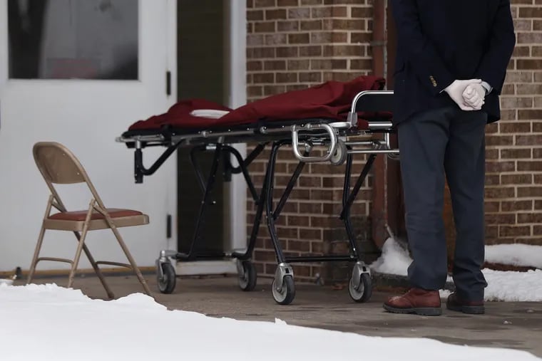 A funeral home worker prepares to pick up the body of a person who died of COVID-19 at a nursing home outside of Lewistown, Pa., last month.