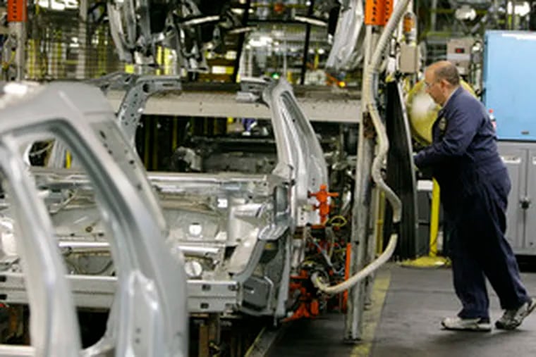 At the Chicago Assembly Plant, a Ford employee works on a 2008 Taurus X. Legislation recently signed by President Bush mandates that automakers improve gas mileage.