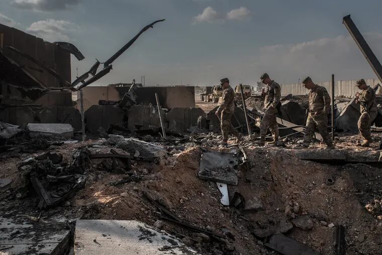 U.S. officials near a crater caused by Iranian airstrikes inside the Ain al-Asad base near Anbar, Iraq, on Jan. 13, 2020.