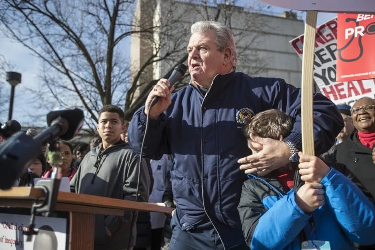 U.S. Rep. Bob Brady covers the ears of a young rally participant as he uses adult language to describe the Republican members of Congress trying to repeal Obamacare at a January 2017 rally.