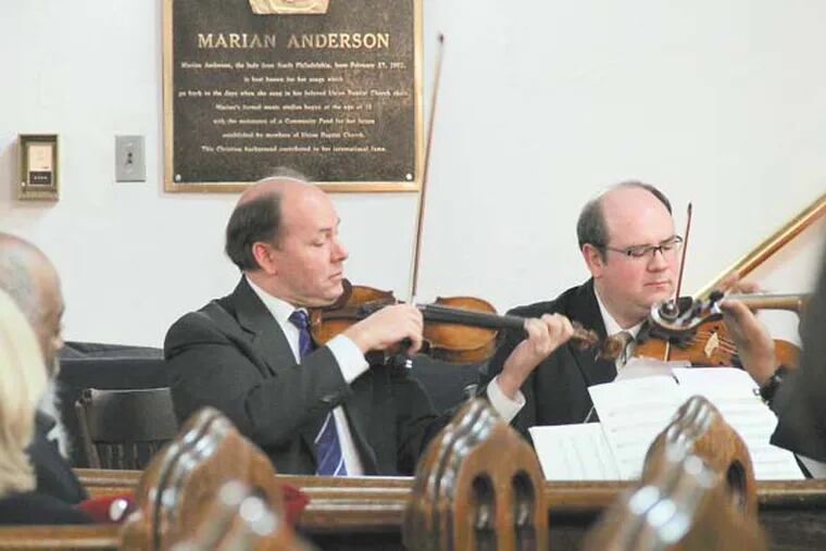 Philadelphia Orchestra violinists Paul Roby (left) and William Polk play at a memorial for conductor James DePreist Monday at Union Baptist Church beneath a plaque honoring DePreist's aunt, celebrated contralto Marian Anderson.