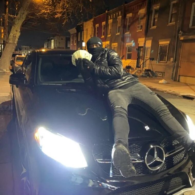 Prosecutors in Chester County say this picture depicts Louis Mendoza posing with a Mercedes and cash stolen from a home in Eassttown Township in January. Mendoza and two other men have been charged with holding the couple who live in that home at gunpoint during the burglary.