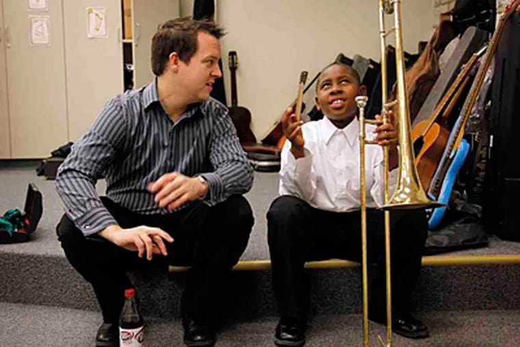 Music instructor Joshua Popejoy goes over some last-minute points with 9-year-old Khiyam Hayes before going on at the St Francis deSales School on Saturday. (Laurence Kesterson / Staff Photographer)
