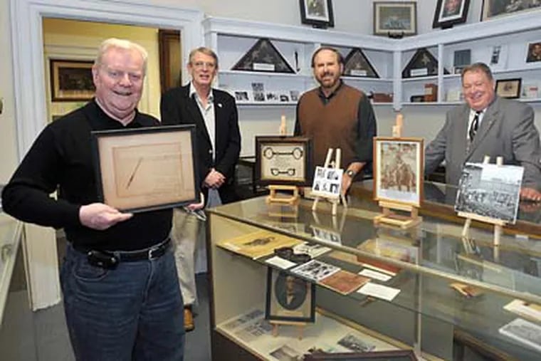 Hugh Boyle (left), board member of the Grand Army of the Republic Civil War Museum and Library, holds a framed strip of pillowcase stained with the blood and brain matter of Abraham Lincoln. Standing behind him are Gary Grove, advisory board, Andy Waskie, vice president of the museum, and Eric Schmicke, president of the museum. (Sharon Gekoski-Kimmel / Staff Photographer)