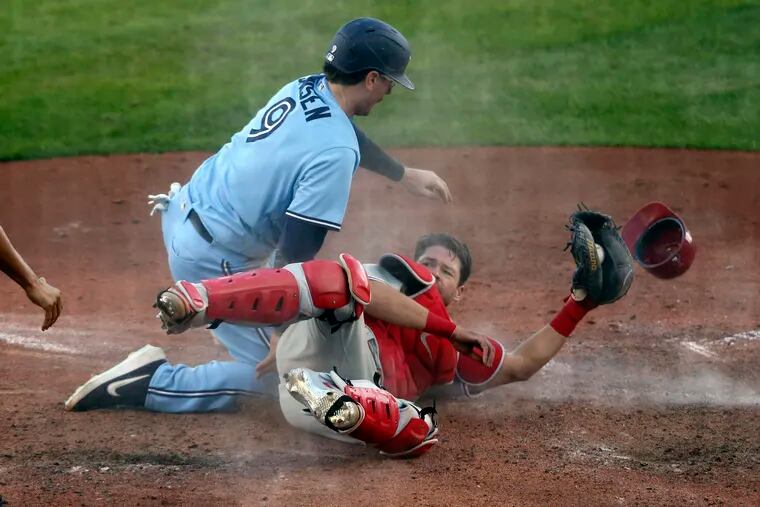 Toronto's Danny Jansen collides with Phillies catcher Andrew Knapp and scores on a wild pitch in the sixth inning of the second game on Thursday.