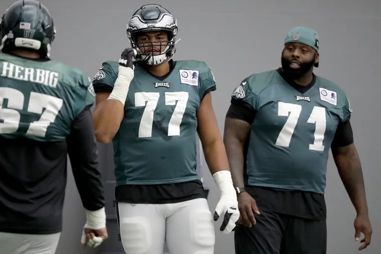 Eagles Andre Dillard (center) waits to take his turn during a blocking drill as Jason Peters (right) watches as the Birds practice on Wednesday, Oct. 16, 2019.