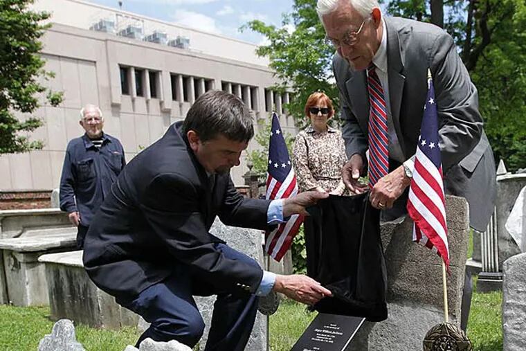 John Hopkins (left) and Allan Hasbrouck unveil the plaque at the burial ground. Hasbrouck is a former Inquirer editor.