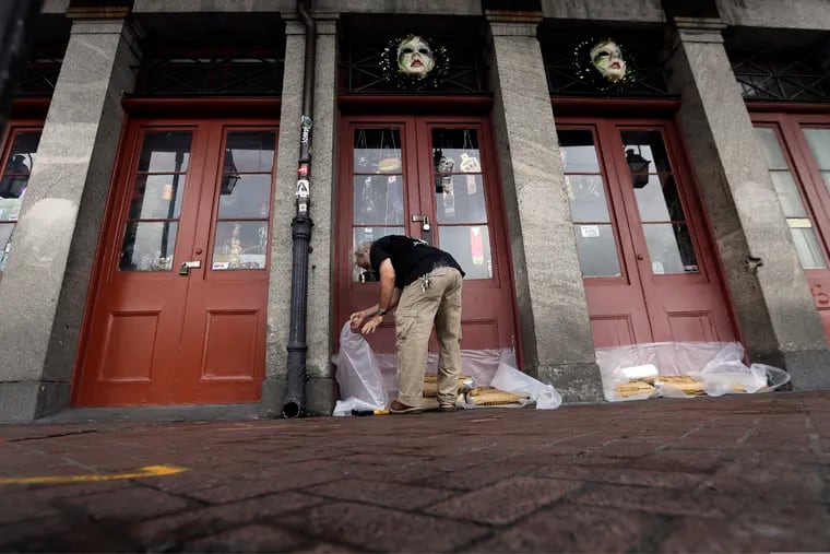 A man puts concrete bags in front of a business in the French Quarter in New Orleans, ahead of Tropical Storm Barry.