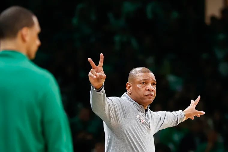 Sixers head coach Doc Rivers raises his fingers as Boston Celtics head coach Joe Mazzulla watches his team during Game 1 of the Eastern Conference playoff semifinals at TD Garden in Boston on Monday, May 1, 2023.