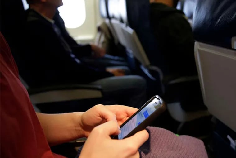 Federal regulators say rules that prohibit making cellphone calls in flight are outdated and are considering changing them. But some frequent fliers fear losing a last bastion of quiet in the world of transportation. (Matt Slocum / AP)