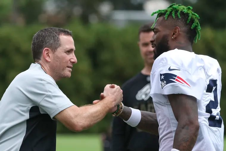 Patriots cornerback Jalen Mills greets Eagles general manager Howie Roseman after a joint training camp with Mills’ former team at the NovaCare Complex in South Philadelphia on Tuesday, Aug. 17, 2021.