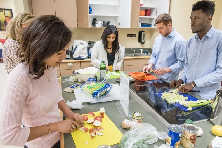 Temple medical students (from left) Mai Stewart, Bushra Anis, David Pioquinto, and Hilario Yankey prepare ingredients for soup and salad.