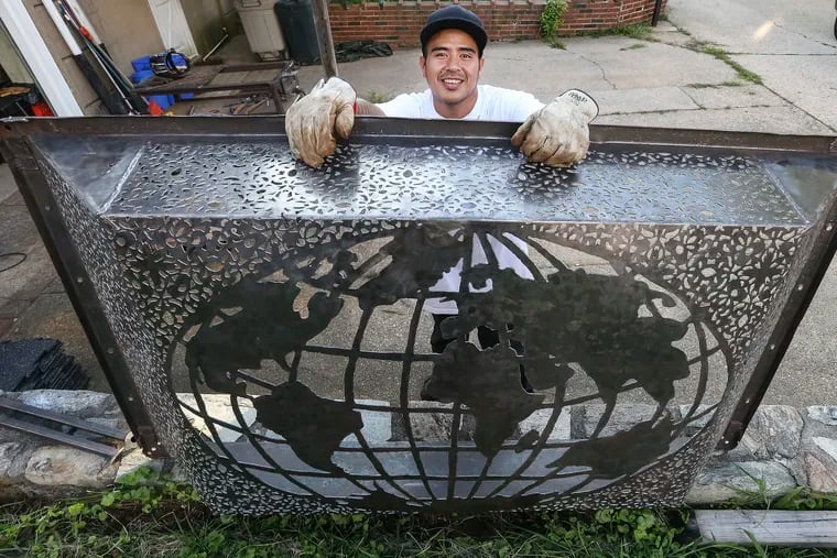 Vanny Channal, sculptor with a globe made from a re-cycled cement mixing tub.Monday, September 3, 2018. STEVEN M. FALK / Staff Photographer