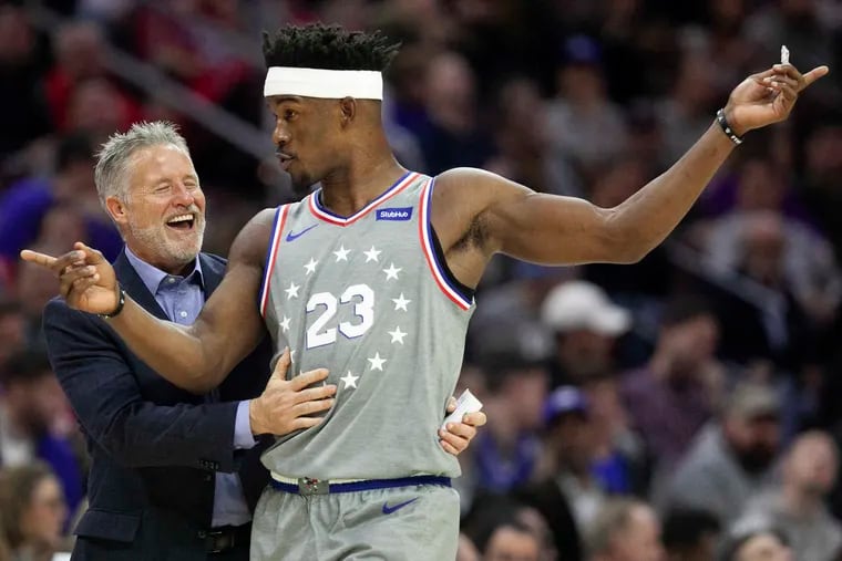 Brett Brown laughs with Jimmy Butler during a Sixers game in November.