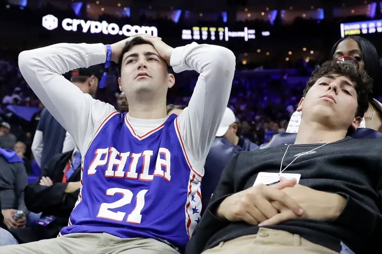 Two dejected Sixers fans try to watch the end of the team's 99-90 loss Thursday night to the Miami Heat in Game 6 of the Eastern Conference semifinals.