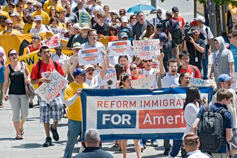 Protesters urging immigration reform in the rally, called &quot;From Philly to Phoenix,&quot; march on the sidewalk on Market Street near 6th, heading toward the Visitors Center yesterday.