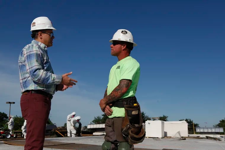 President of EDA Contractors Edward DeAngelis (left) and site foreman Ian Pollini talk on the roof of the Bellmawr Post Office in Bellmawr, NJ, on the morning of Thursday, June 14, 2018. Construction company EDA Contractors is training its roofers and carpenters, some of its most masculine workers, how to be emotionally intelligent. MAGGIE LOESCH / Staff Photographer