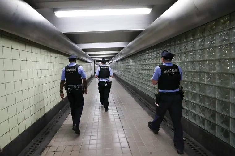 SEPTA police officers Kevin Newton, left, Anthony Capaldi, center, and Martin Zitter enter the 13th street El station on Market St. in Philadelphia on Wednesday, May 31, 2023.