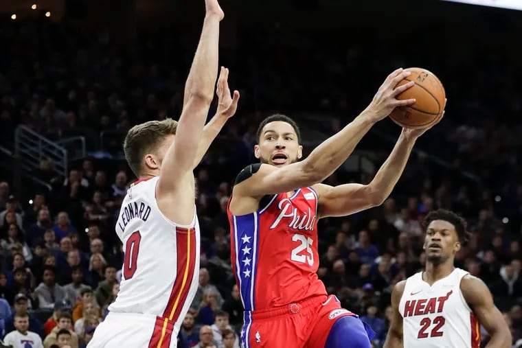 Sixers guard Ben Simmons drives to the basket against Miami Heat forwardd Meyers Leonard and Jimmy Butler.