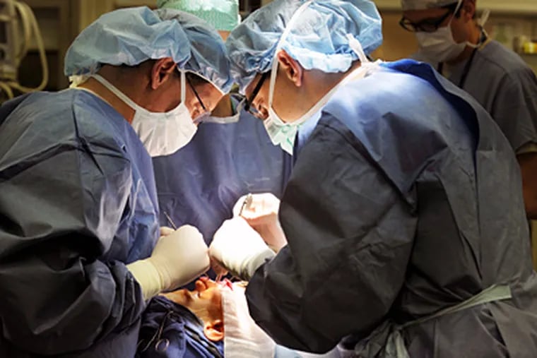 Scott Bartlett (left), chief of plastic surgery, and Chris Derderian, a craniofacial fellow, perform surgery on Gerard McGrenaghan, 17, of Gloucester County, at Children's Hospital of Philadelphia. (Sarah J. Glover / Staff Photographer)