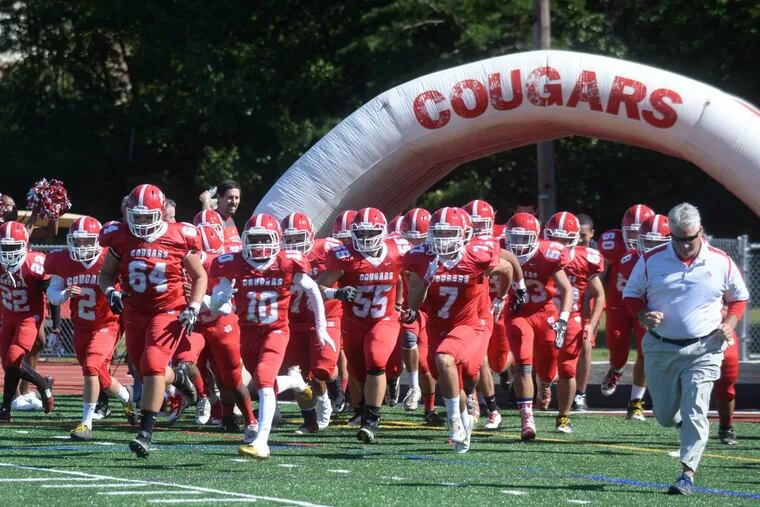 Tom Coen (right) and Cherry Hill East take the field for the 2017 season opener vs. Paul VI.