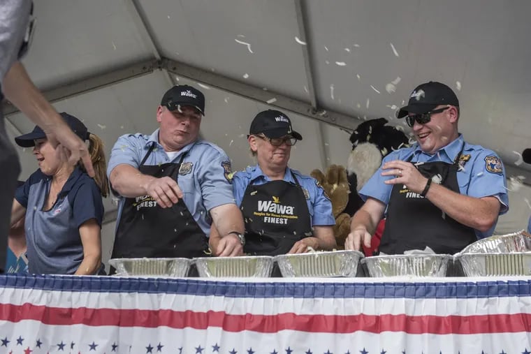 Members of the Philadelphia Police Department have lettuce thrown at them during a sandwich making competition at Wawa's Hoagie Day at Independence Mall on Thursday, June 28, 2018.