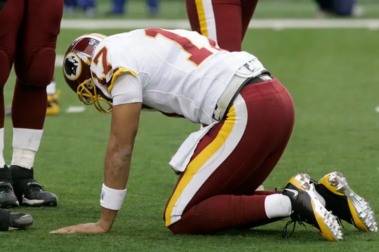 Washington quarterback Jason Campbell struggles to his feet after being hit by the Bengals.
