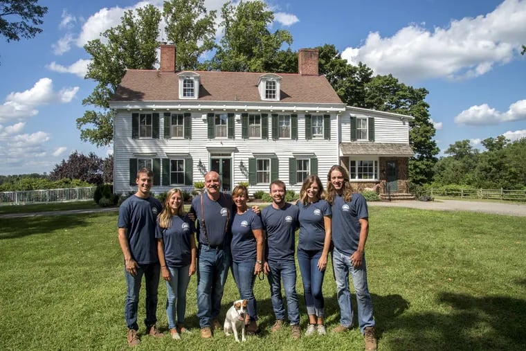 The Johnson family, current owners of the historic Locust Hall Farm in Jobstown, gather in front of the farmhouse in the middle of the 325-acre spread. From left are son Wes Johnson and his wife, Kaitlin; father Pete and mother Brenda; son Will and his wife, Allie, and son Jim, and Chip the Jack Russell terrier.