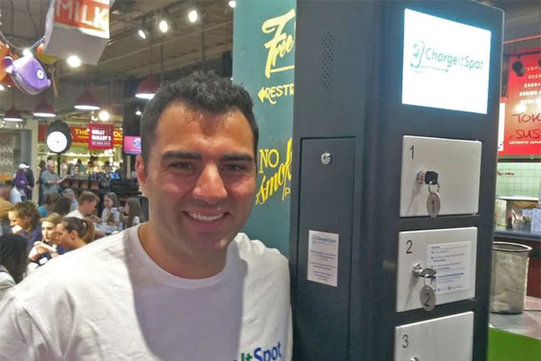 ChargeItSpot founder Doug Baldasare, next to one of his firm's cellphone-charging stations, installed at Reading Terminal Market. (Mike Armstrong / Staff)