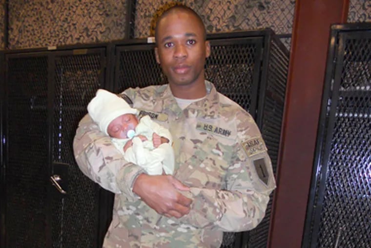 Demetrius M. Frison, 26, an Army first lieutenant with his baby son, Christopher. Frison was killed Tuesday by a bomb, his wife said.