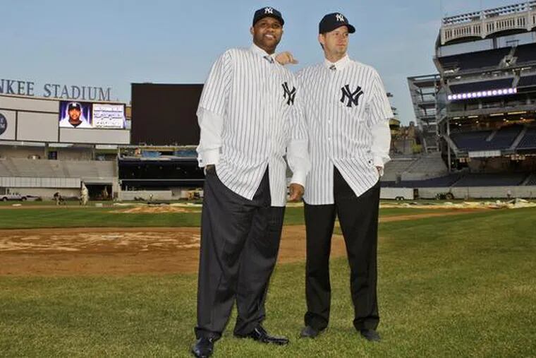 CC Sabathia (left) and A.J. Burnett, the Yankees&#0039; latest signings, strike poses on the field at the new Yankee Stadium.
